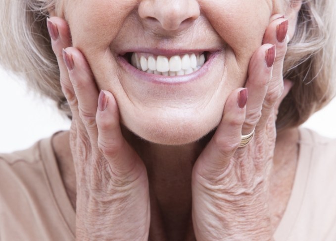 Smiling senior woman touching her face