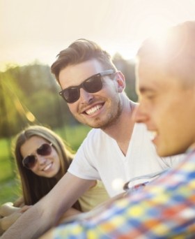 Group of people smiling outdoors in sunglasses