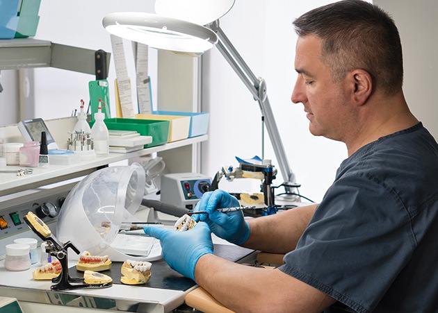 a dental lab technician crafting dentures